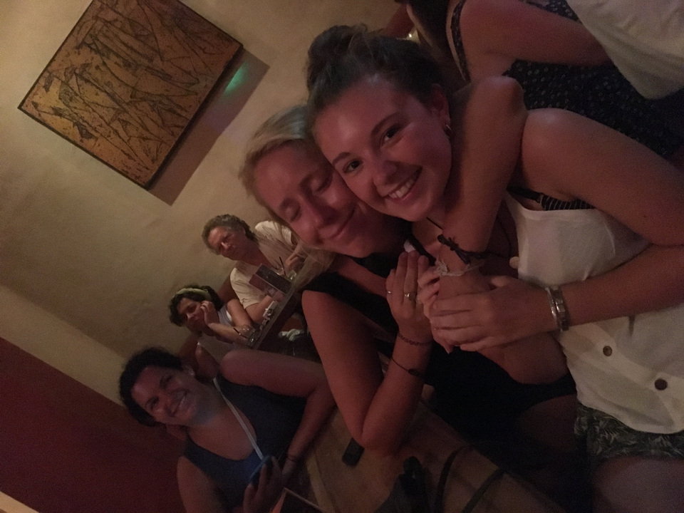 Group of friends inside a room, dim lighting.