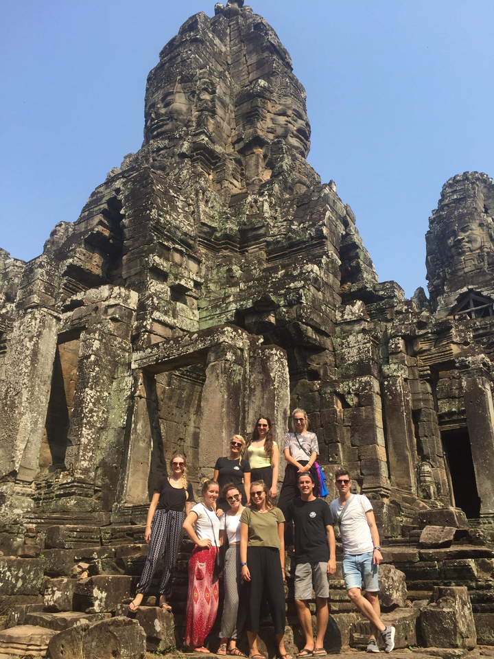 People posing in front of ancient ruins.