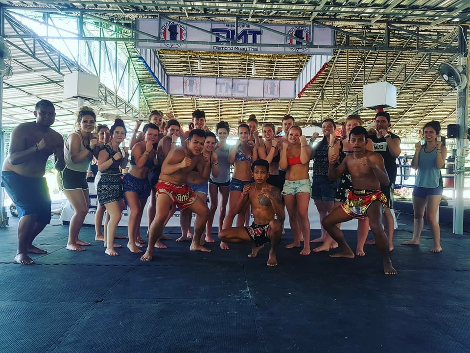 Group of people posing in a martial arts training area.