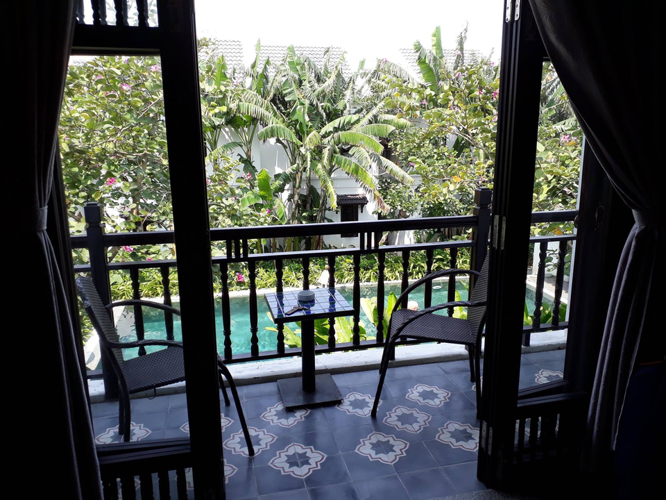Vue d'un balcon avec des chaises et un jardin tropical.