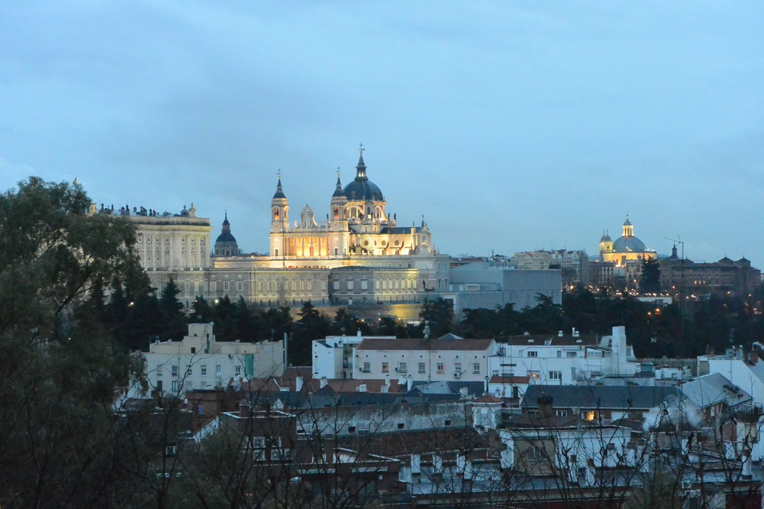 Paysage urbain avec des bâtiments historiques illuminés au crépuscule.