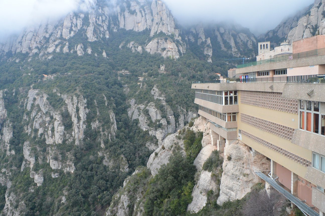 Bâtiment intégré au flanc rocheux de la montagne.