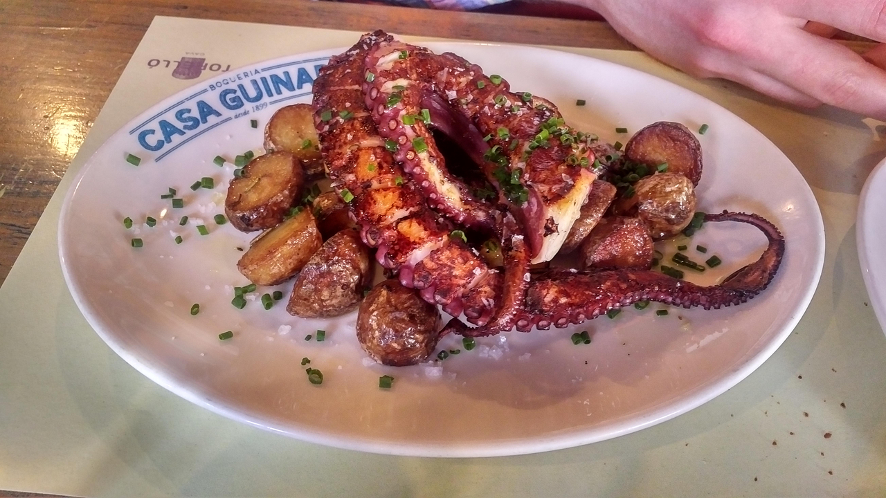 Assiette de poulpe et de pommes de terre servie dans un restaurant.