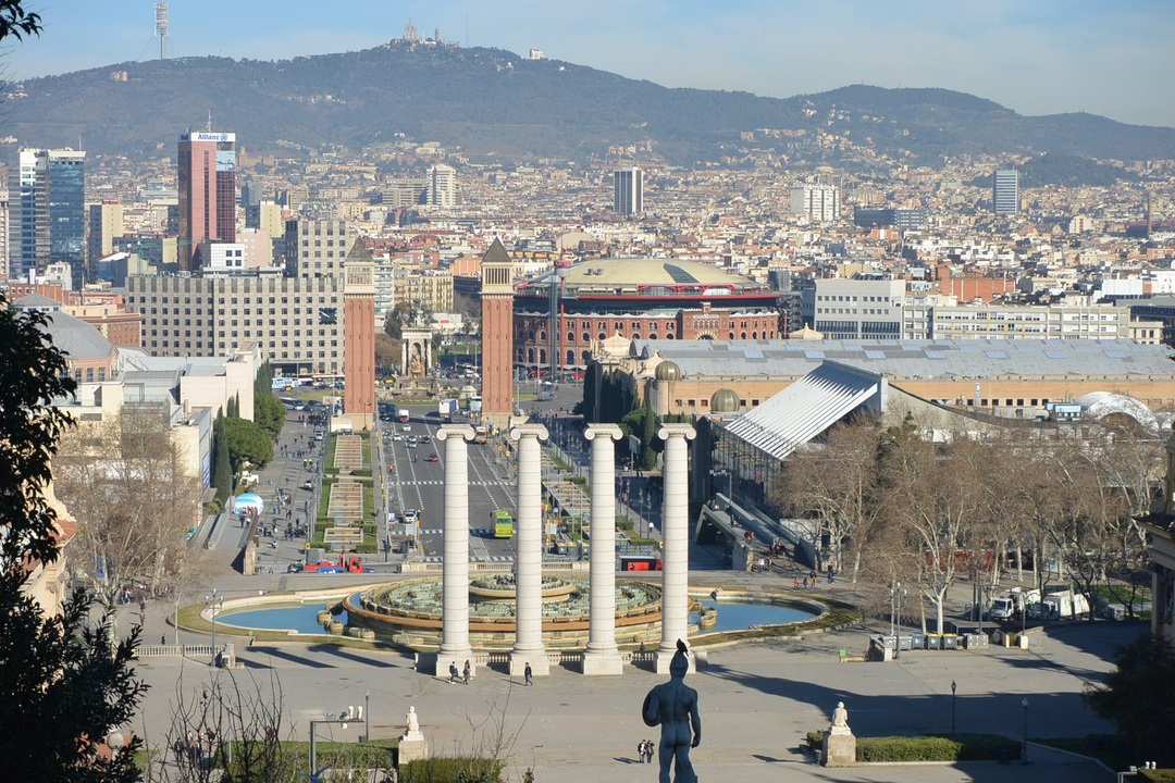 Vue panoramique d'une ville avec une fontaine et des structures architecturales.