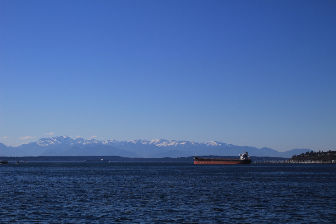A ship on the water with mountains in the background.