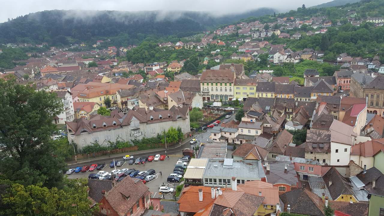Aerial view of a picturesque town with colorful rooftops and surrounding greenery.
