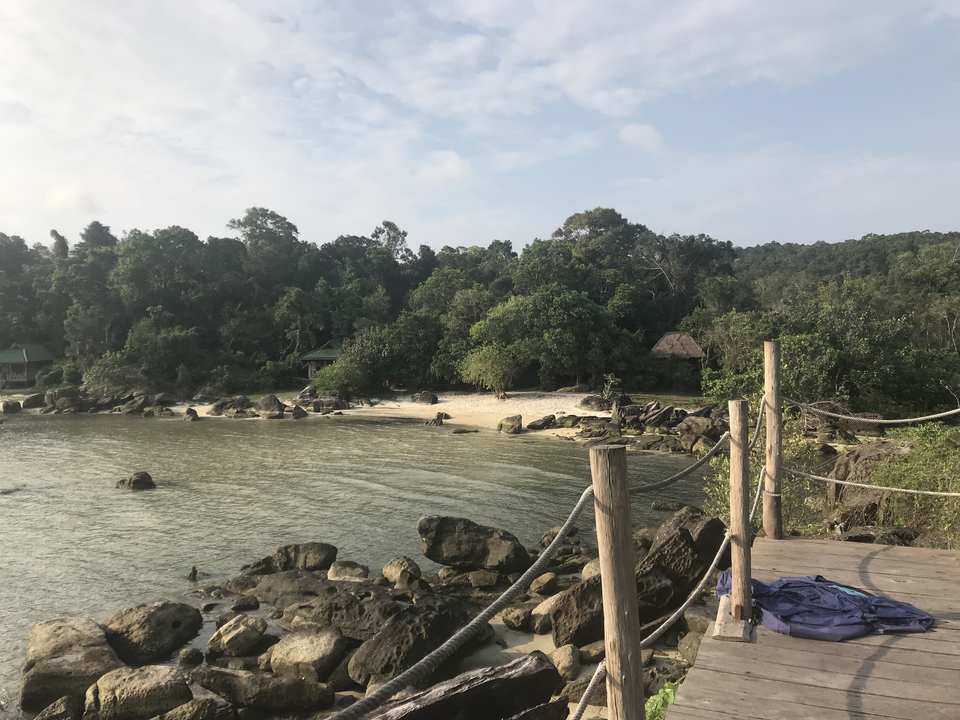 Secluded sandy beach with lush green trees in the background.