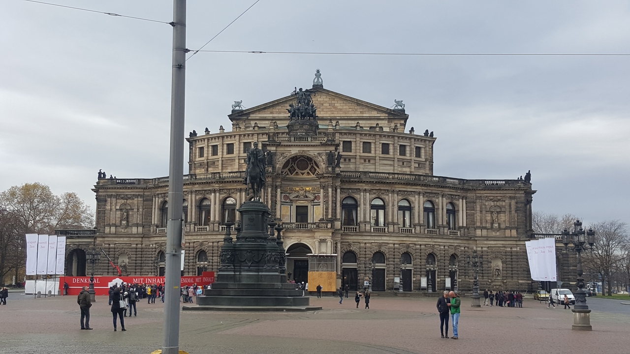Baroque opera house facade with a large statue in front
