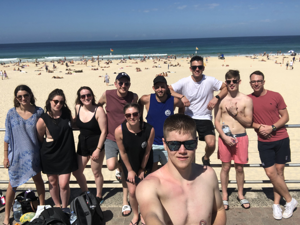 Group of friends posing by the beach on a sunny day.