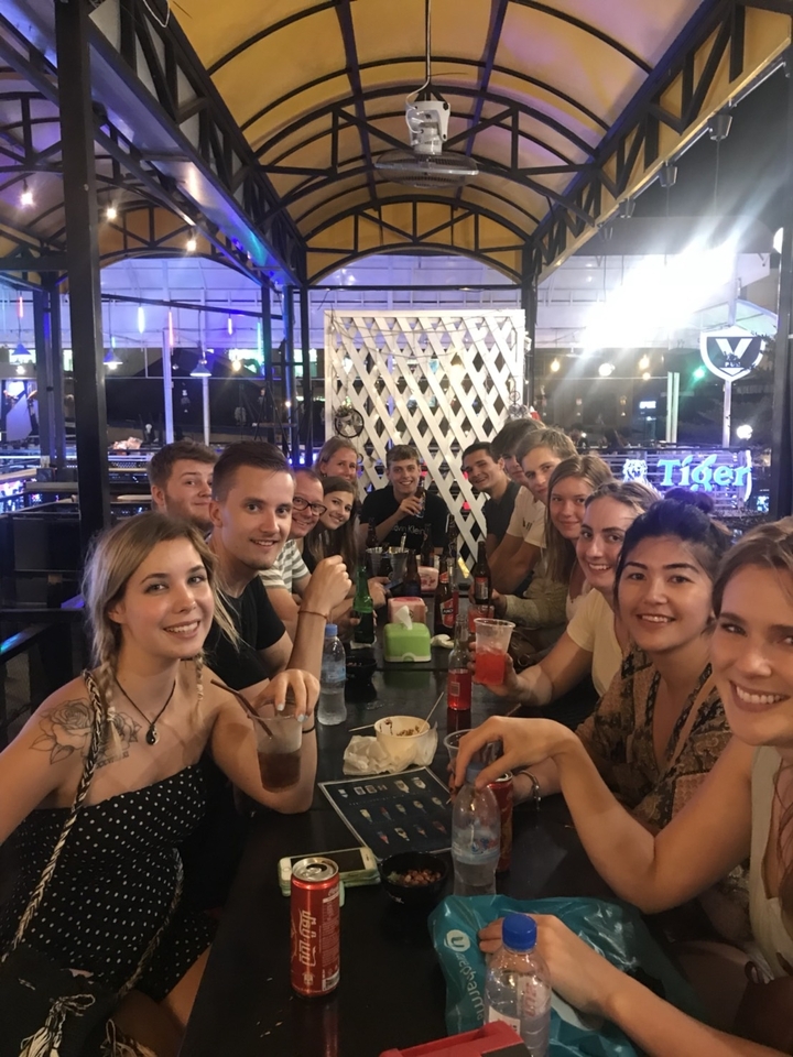 Group photo of people dining together in a lively atmosphere.