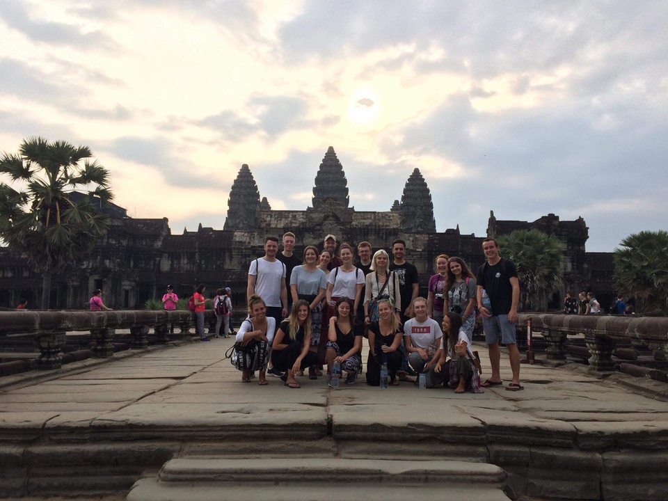Group posing in front of Angkor Wat temple.