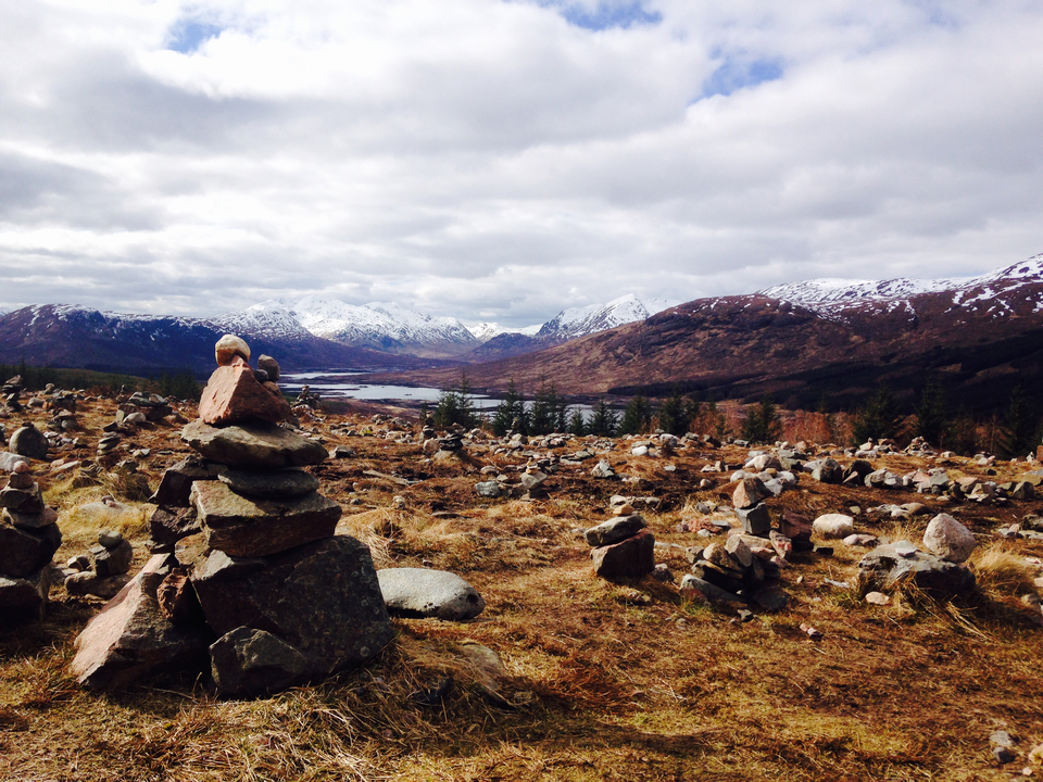 Rocky landscape with cairns and mountains in the background.