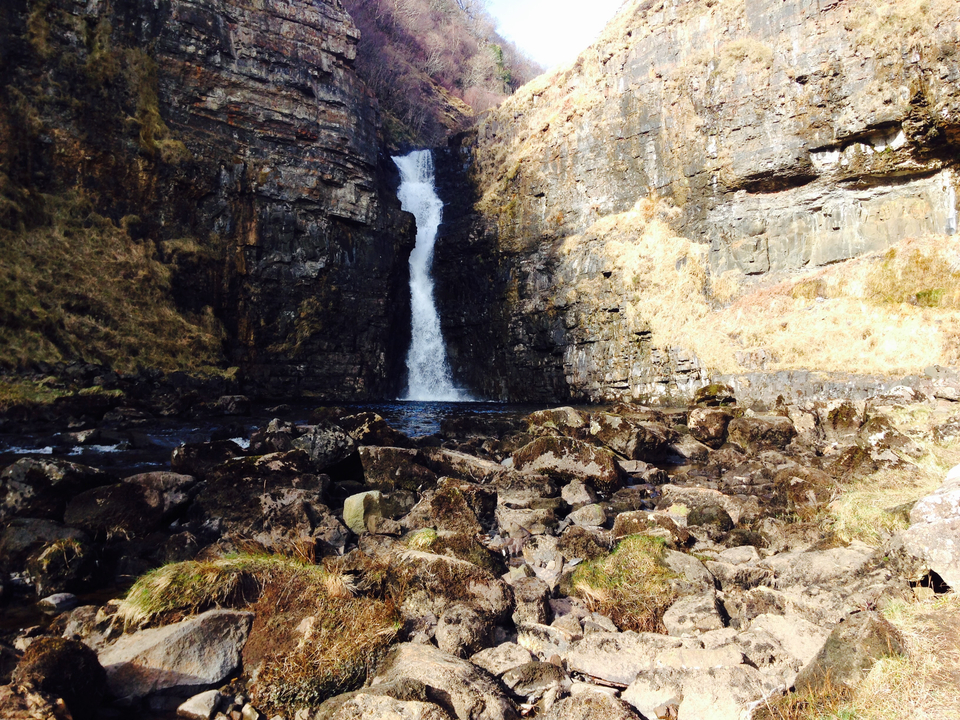 Waterfall cascading into a rocky pool.