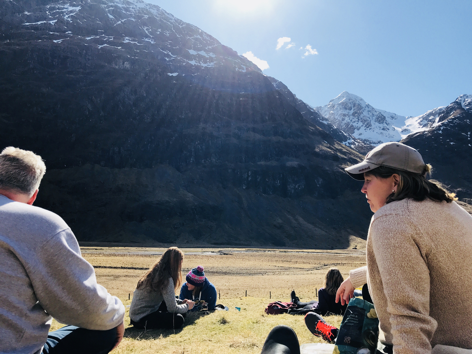A group of people relaxing in a mountain landscape.