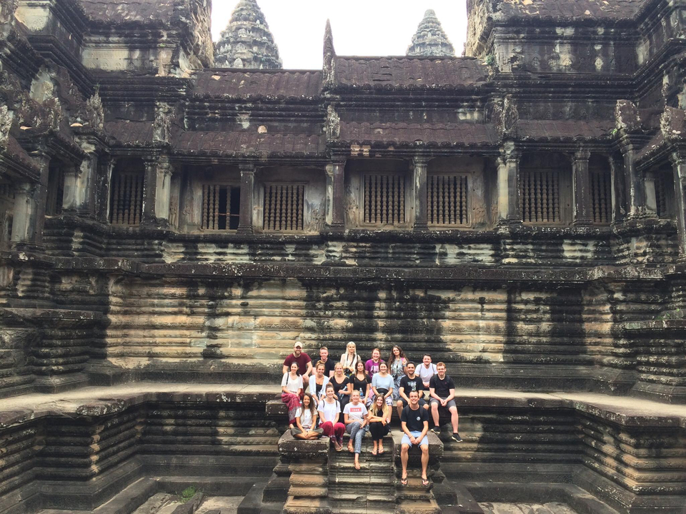 Group of tourists posing in an ancient temple.