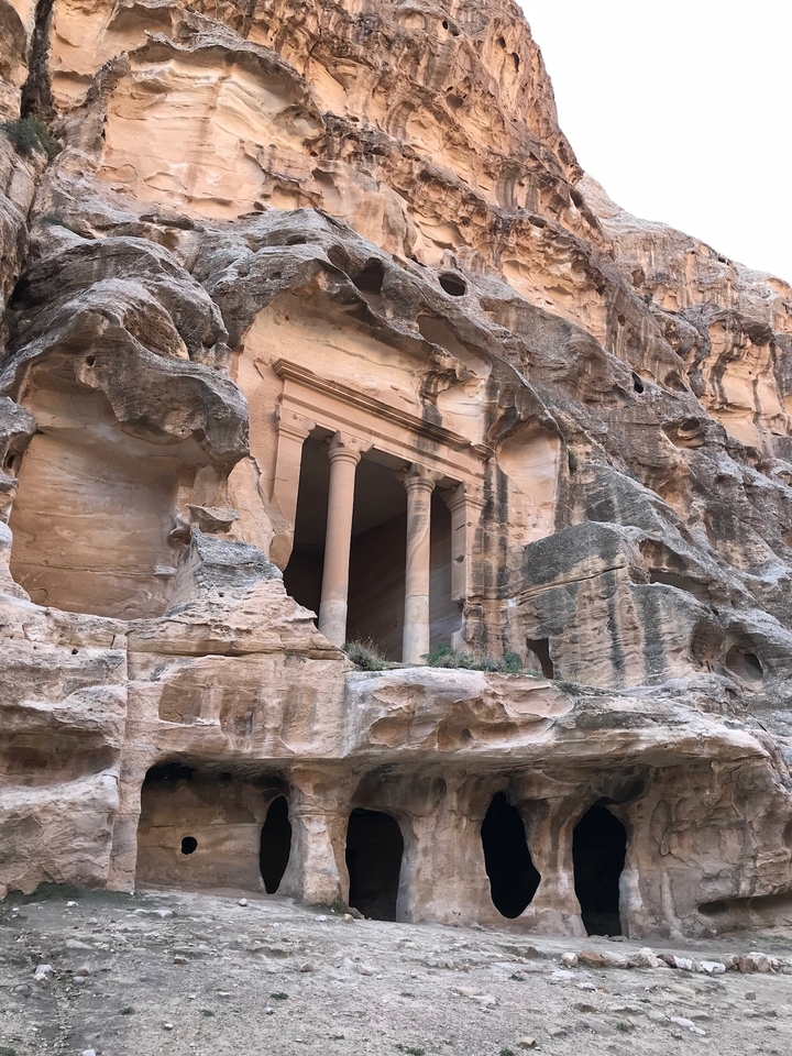 Rocky facade with ancient columns.