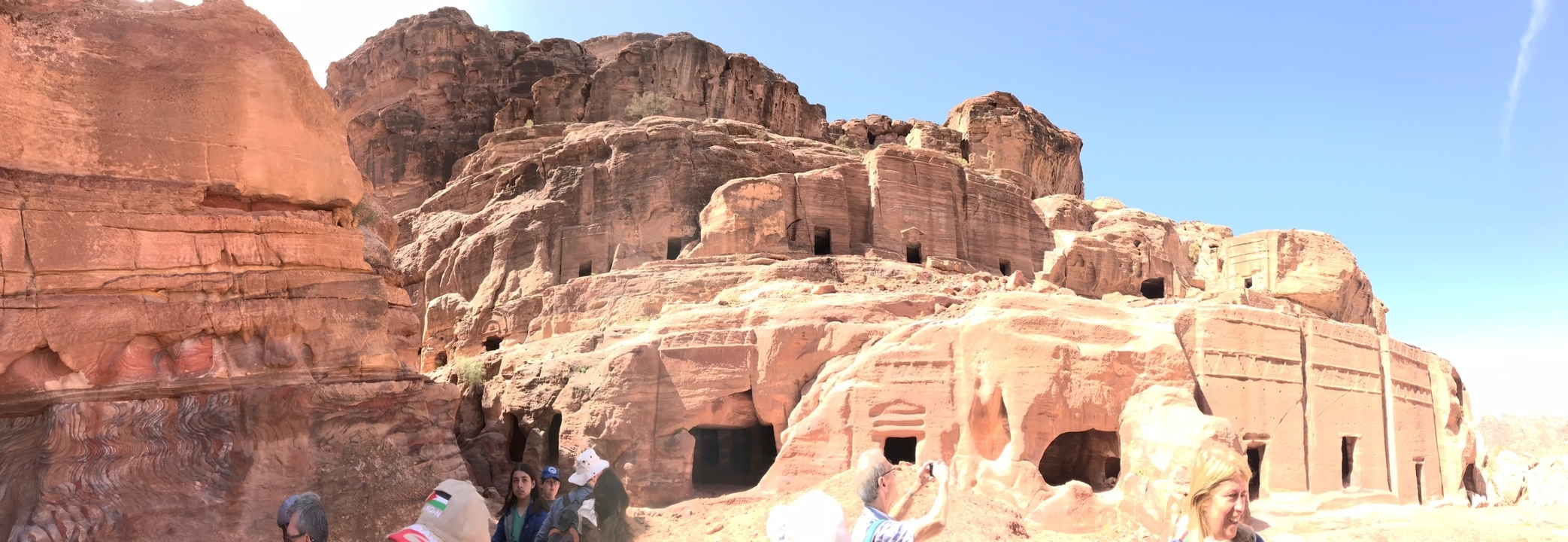 People exploring ancient rock-cut architecture.