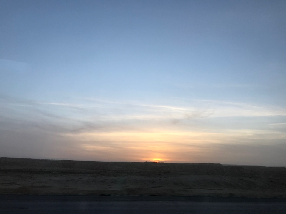 Sunset over a flat desert landscape.