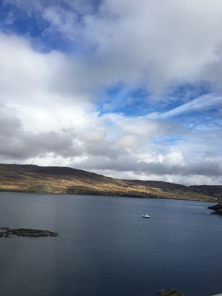 Scenic view of a coastline with clouds and blue sky.