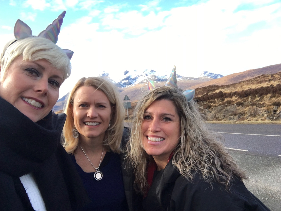 Three women taking a selfie with mountains in the background.