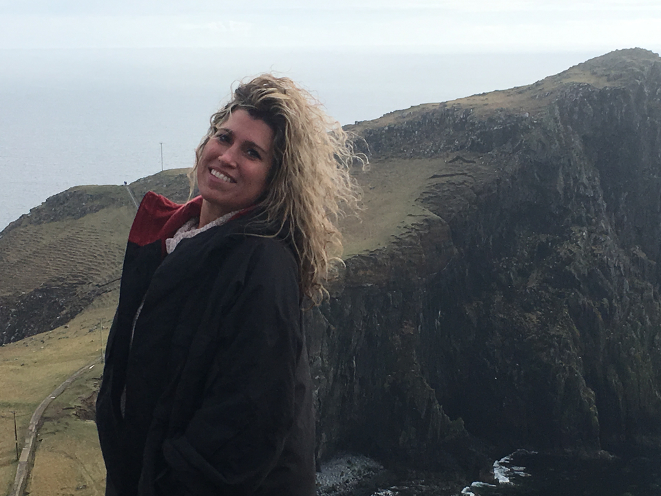 Woman posing in front of a cliff.