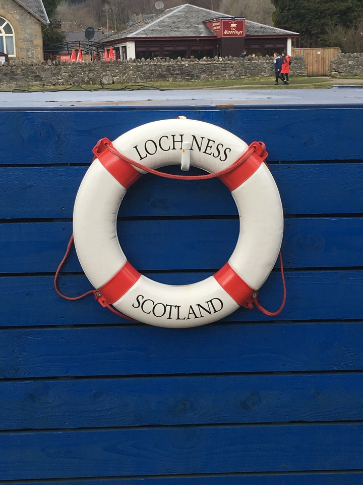 Lifebuoy with 'Loch Ness Scotland' written on it against a blue wall.