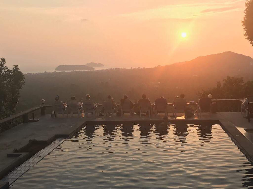 People enjoying a sunset view by the pool.