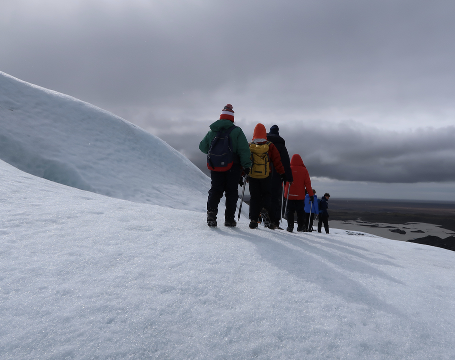 Hikers walking on a snowy landscape.