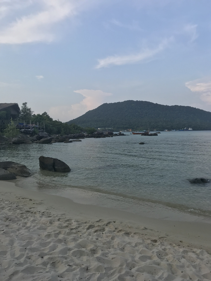 Scenic view of a calm beach with mountains in the background.