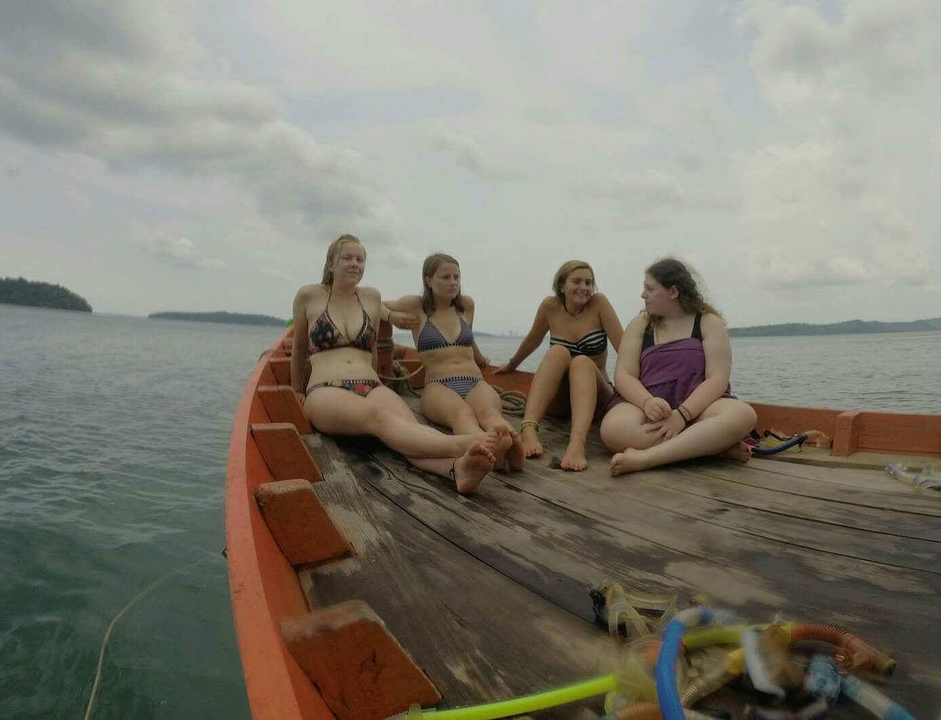 Group of friends relaxing on a boat out at sea.