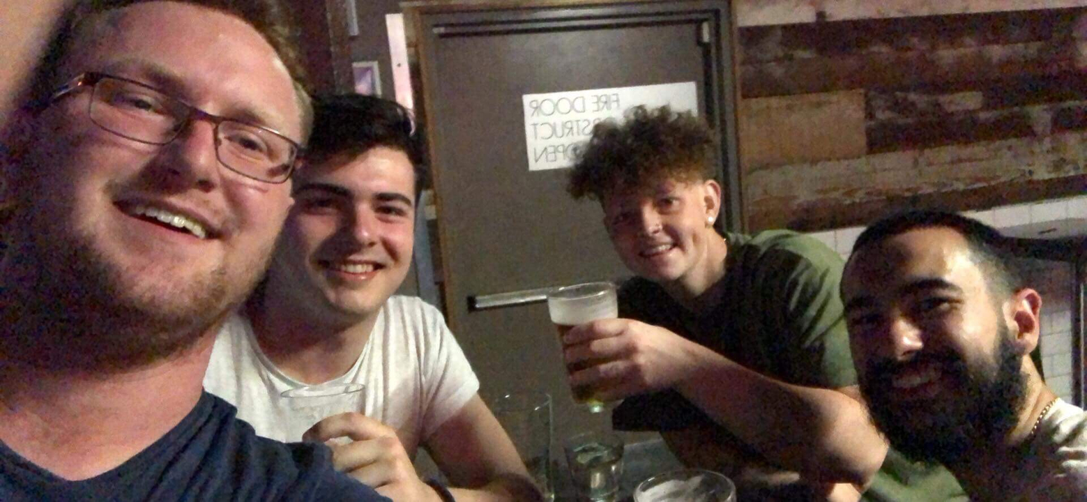 Group of friends enjoying drinks inside a bar.