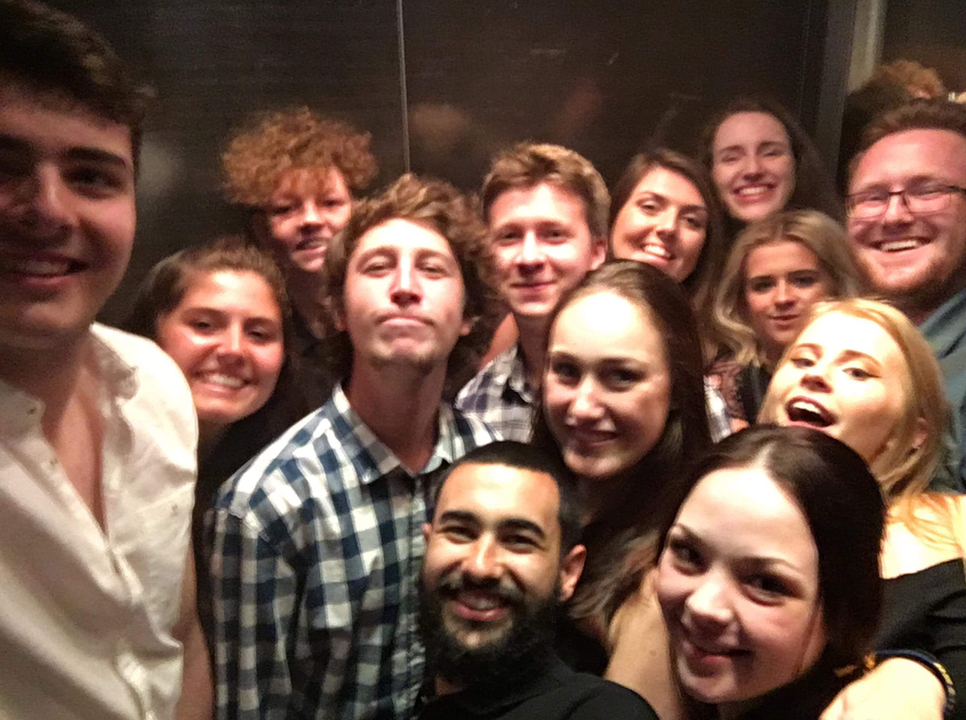 Group selfie inside with happy expressions.