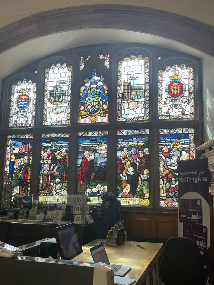 Stained glass windows depicting historical scenes.