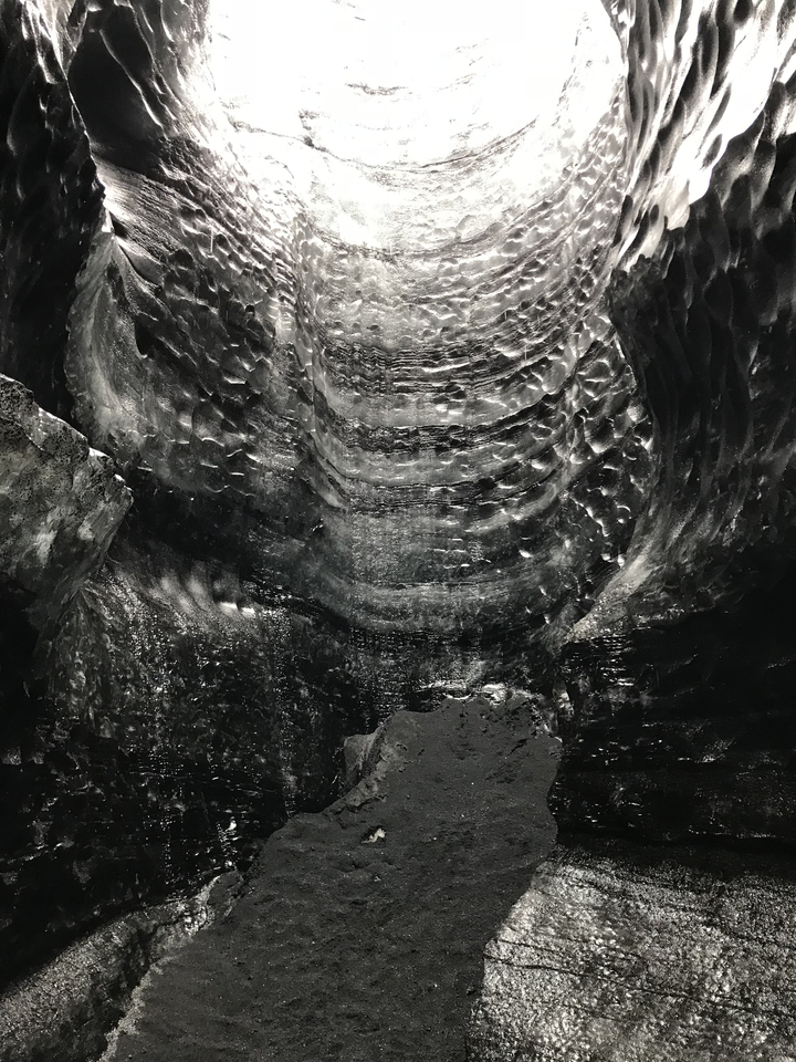 Inside view of an ice cave with a textured ceiling.