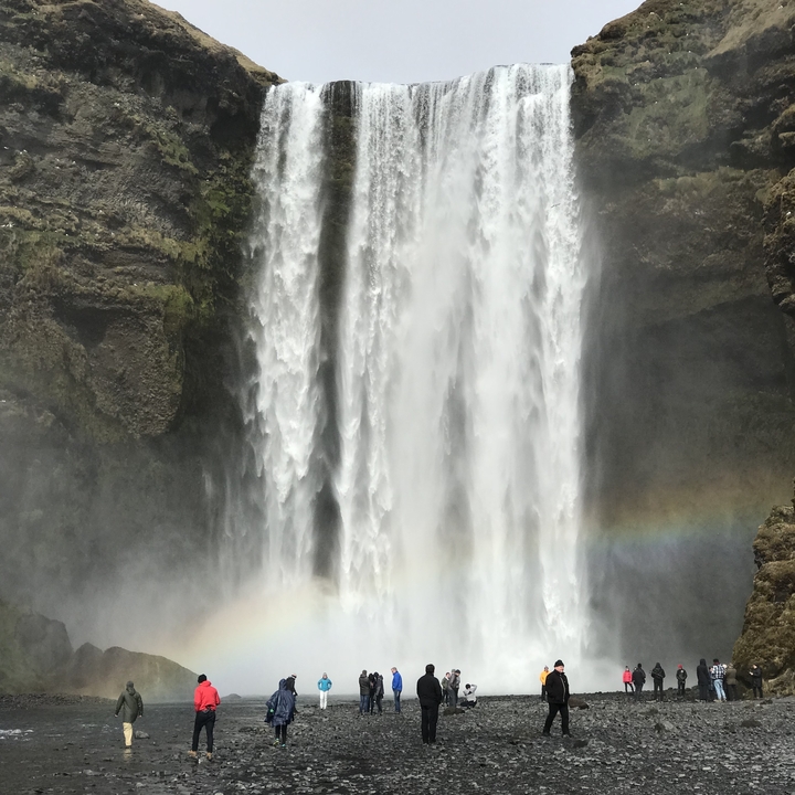 A large waterfall with a rainbow visible at the base.