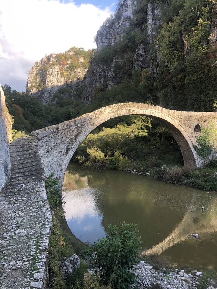 Old stone bridge over a river in a mountainous area.