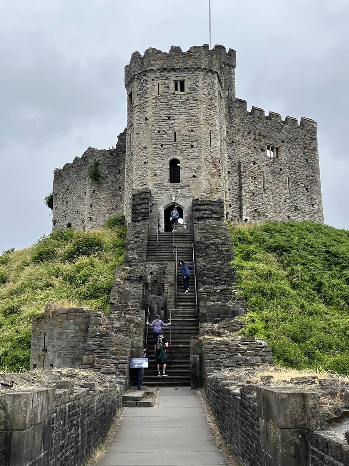 Stone castle with tourists exploring the entrance.