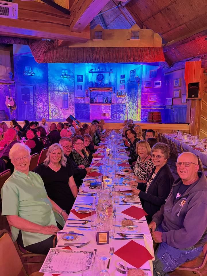 Large group of people seated around a table in a festive setting.