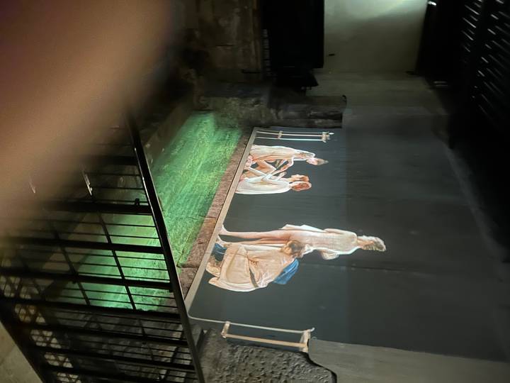 A projection of dancers in an indoor environment.