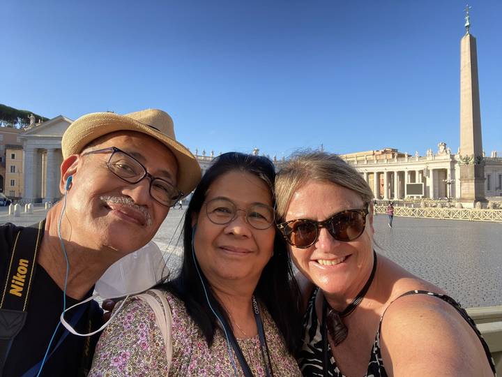 A group of people taking a selfie in a historic setting.
