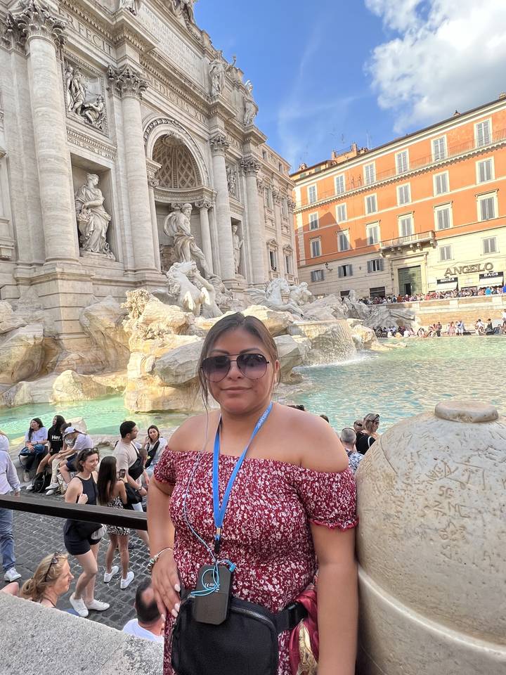 Woman posing in front of the Trevi Fountain.