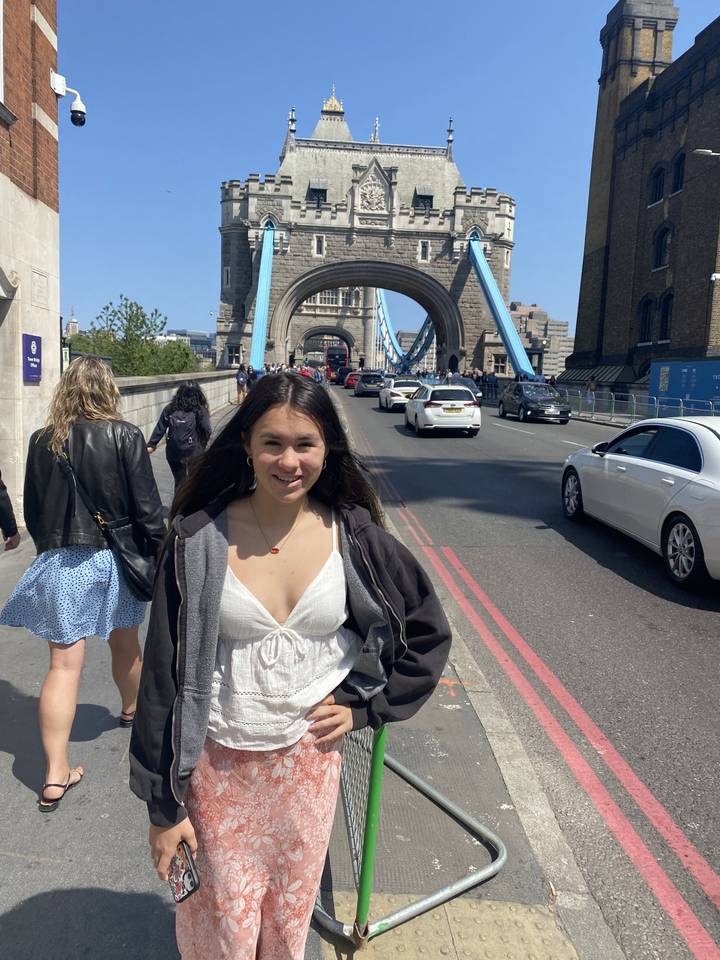 Person posing with Tower Bridge in the background.