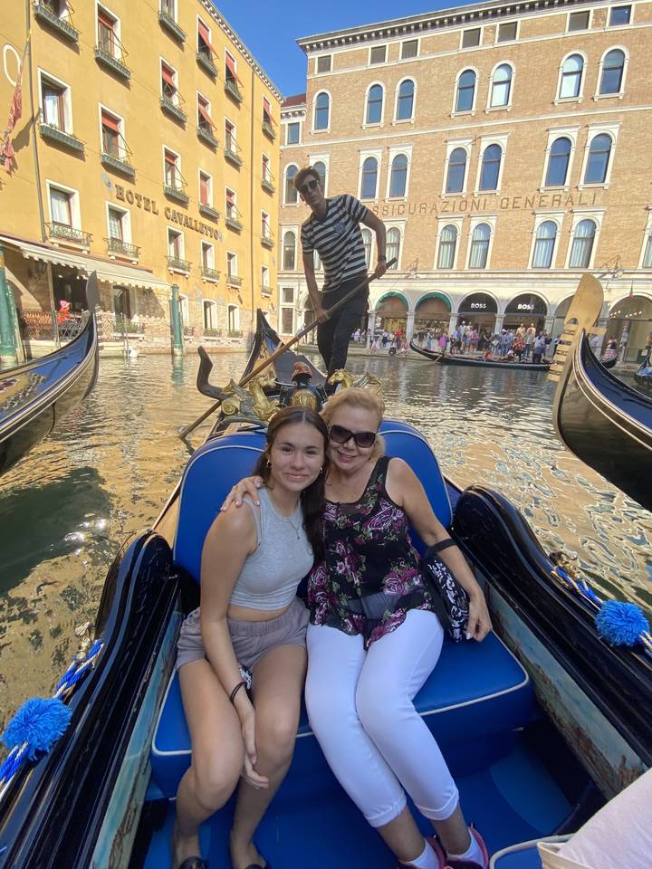 Two people sitting in a gondola on a canal in Venice.