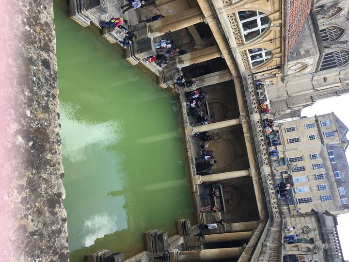 Bain romain historique avec des gens autour.