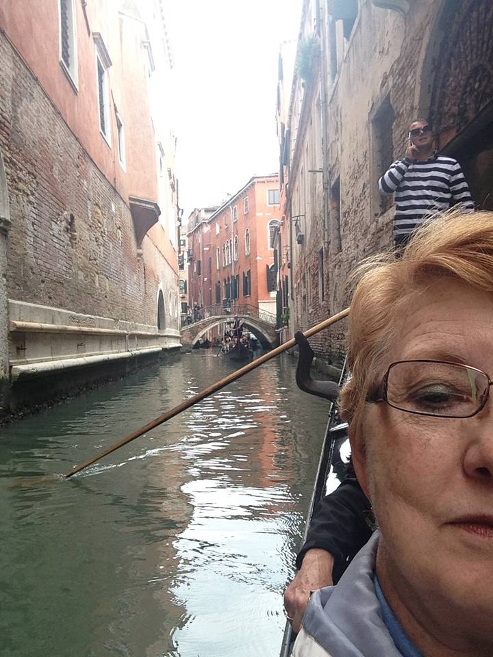 Personne se promenant en gondole sur un canal à Venise.