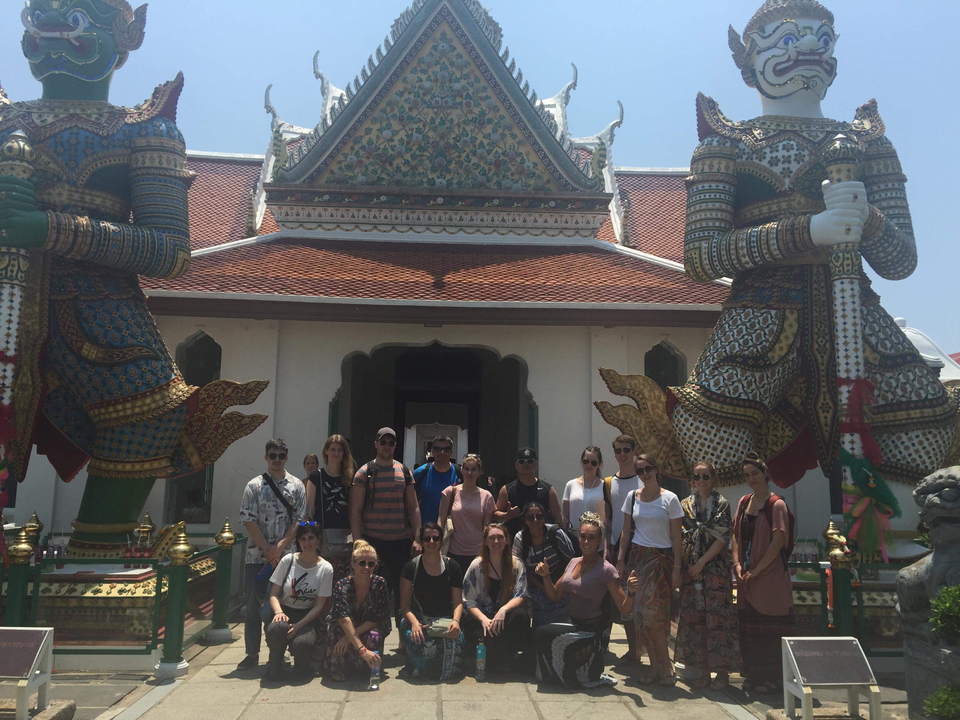 Group photo in front of a temple with large guardian statues.