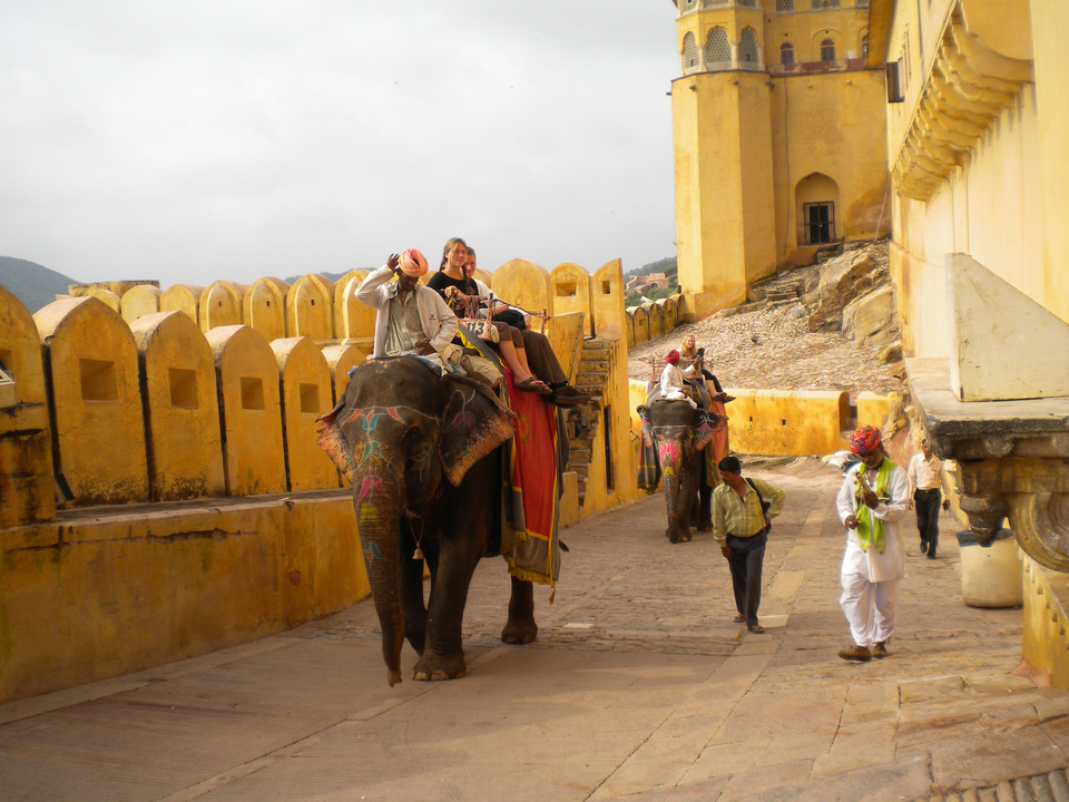 Elephants with riders inside a historic fort.