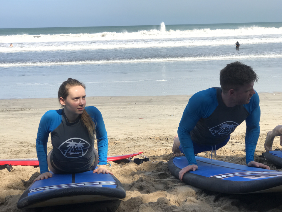 People practicing yoga on surfboards at the beach.