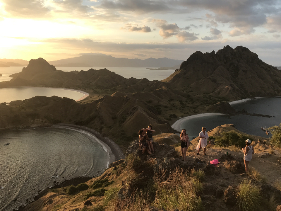 Sunset view at a scenic landscape with mountains and ocean.