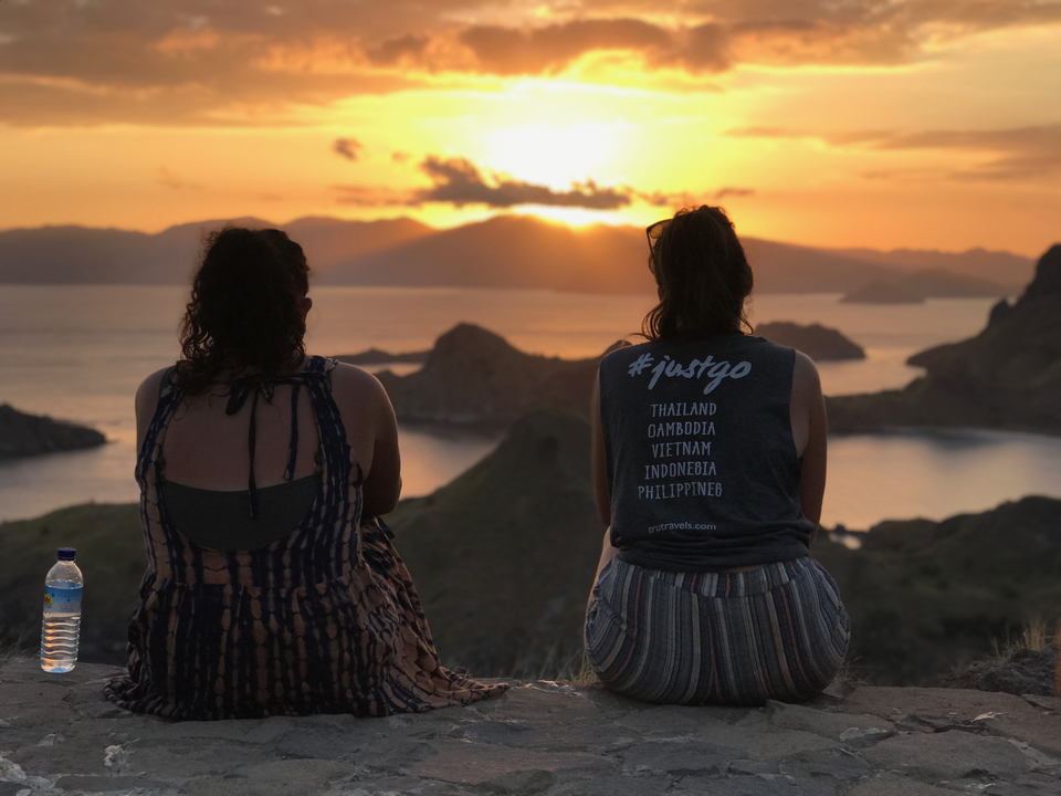 Two people watching sunset at a scenic viewpoint.